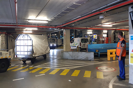 Busy luggage gallery interior at charleroi airport with pedestrian and ground support equipment